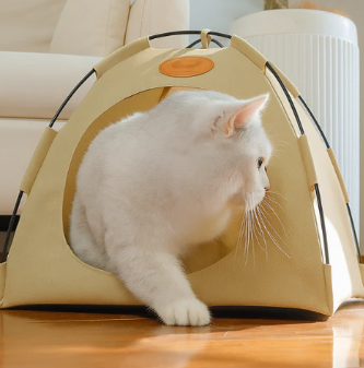 White cat lounging at the entrance of a beige portable cooling pet tent with mesh sides, in a bright indoor setting